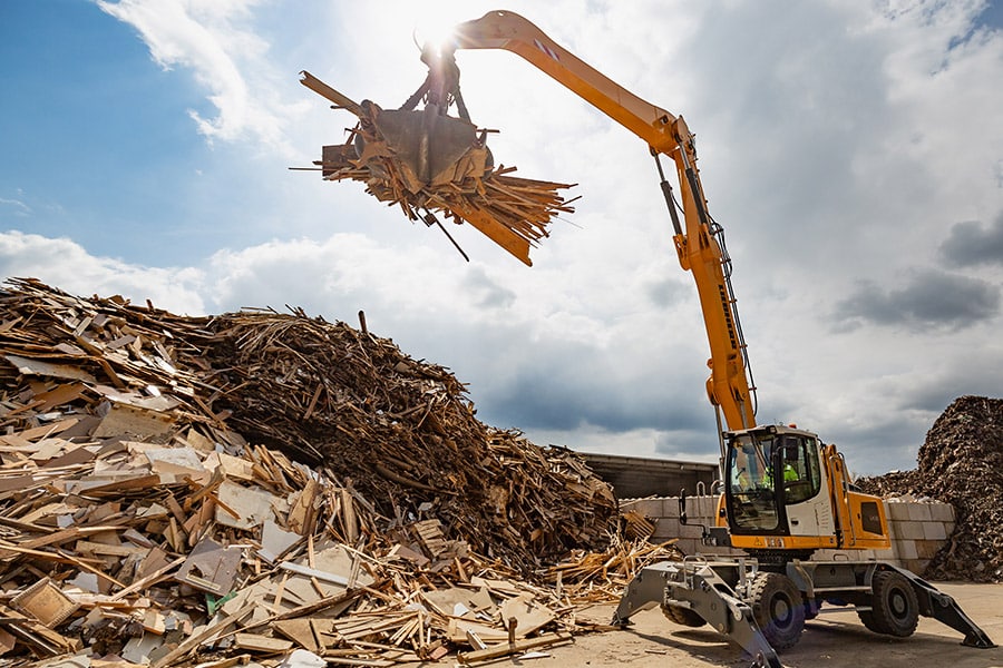 Kran sortiert Altholz